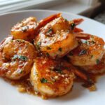 Close-up of succulent Fried Garlic Butter Shrimp coated in a rich, glossy sauce with visible minced garlic and parsley.