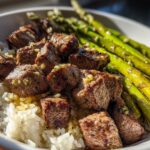 Close-up of a Garlic Butter Steak Bowl Weeknight Dinner featuring steak bites over white rice with bright green asparagus.