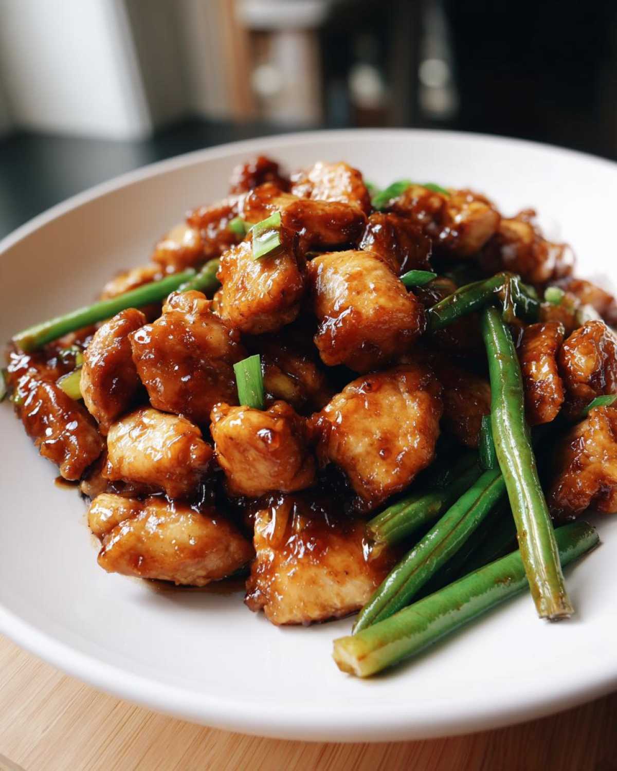 Close-up of saucy, glazed chicken pieces mixed with vibrant green beans, a delicious chicken and green beans dish.