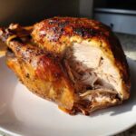 Close-up of a perfectly roasted turkey breast, sliced open to show moist, shreddable meat, a result of the turkey brine.