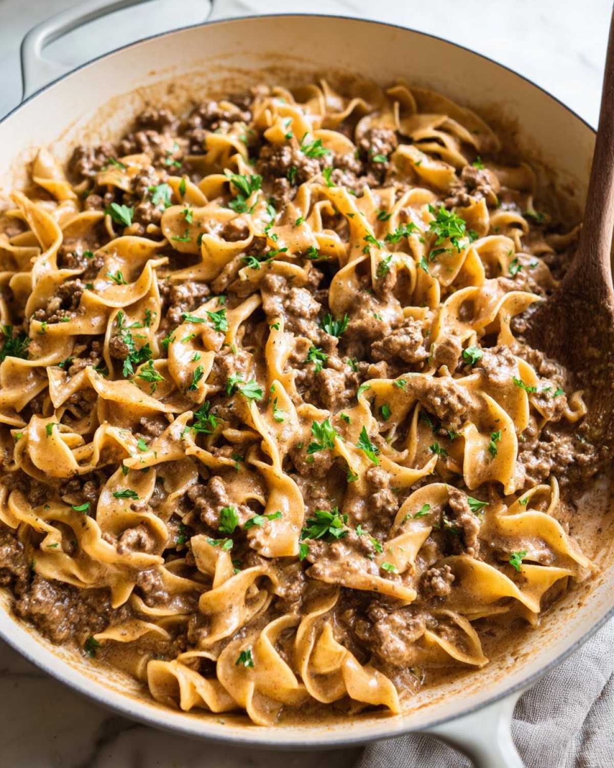 Close-up of creamy One Pan Ground Beef Stroganoff with egg noodles and ground beef, garnished with fresh parsley.