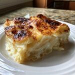 A thick slice of creamy Paula Deen Scalloped Potatoes with a beautifully browned and bubbly cheese crust.