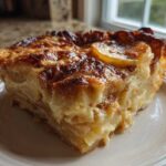 A close-up of a rich, creamy slice of Paula Deen Scalloped Potatoes with a deeply browned, cheesy top.