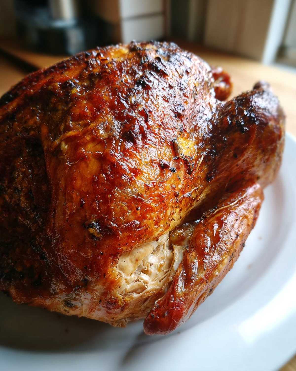 Close-up of a perfectly roasted turkey with crispy, golden-brown skin, showing moist meat after a turkey brine.