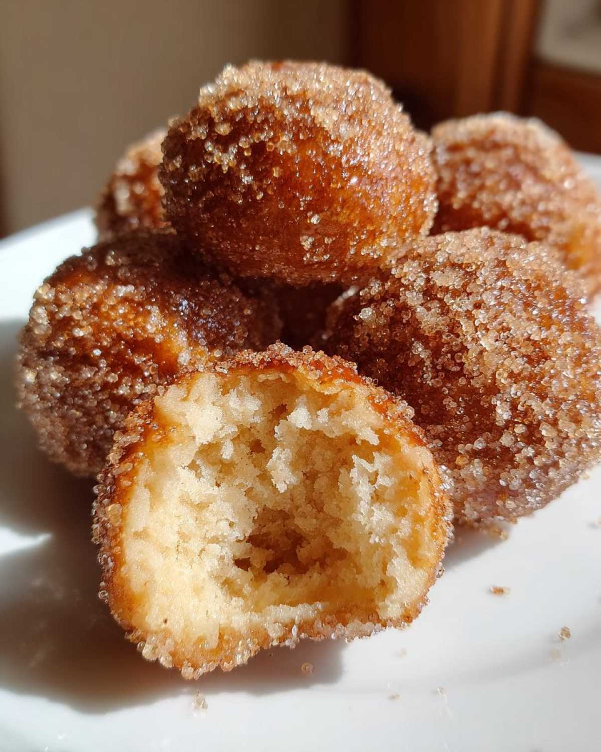 A close-up showing the soft interior of one of the Soft & Sweet Cinnamon Sugar Biscuit Bites, coated in sparkling cinnamon sugar.