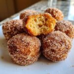 A stack of golden Soft & Sweet Cinnamon Sugar Biscuit Bites, one broken open to show the fluffy interior.
