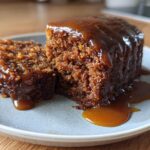 Close-up of a rich, moist slice of sticky toffee pudding recipe covered in thick toffee sauce.