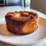Close-up of a perfectly baked French Toast Muffin with a dark, caramelized, sugary top.