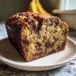 Close-up of a freshly baked Chocolate Chip Banana Bread loaf showing moist texture and melted chocolate chips.