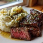 Perfectly cooked Garlic Butter Steak with Creamy Mash, showing a medium-rare center and herb butter sauce.