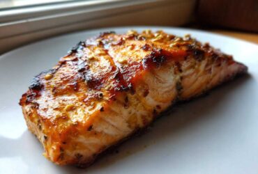 Close-up of a perfectly grilled salmon fillet coated in a shiny, caramelized Salmon Marinade for Grilled Dinner.