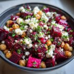 A close-up view of a bowl filled with a vibrant Refreshing Chickpea Beet Feta Salad, featuring cubed beets, chickpeas, and crumbled feta.