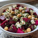 A white bowl filled with colorful Refreshing Chickpea Beet Feta Salad, featuring bright magenta beets, white feta cheese, and chickpeas.