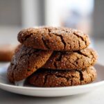 A stack of four dark brown Soft & Chewy Molasses Cookies, generously coated in sparkling sugar crystals.