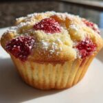 A close-up of a freshly baked Strawberry Shortcake Muffins Recipe Easy 5-Minute Snack Idea dusted with powdered sugar.