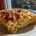 A close-up slice of creamy Dump and Bake Mac and Cheese with a perfectly browned and bubbly cheese crust.