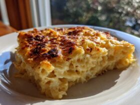 A close-up slice of creamy Dump and Bake Mac and Cheese with a perfectly browned and bubbly cheese crust.