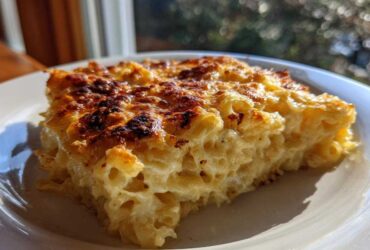 A close-up slice of creamy Dump and Bake Mac and Cheese with a perfectly browned and bubbly cheese crust.