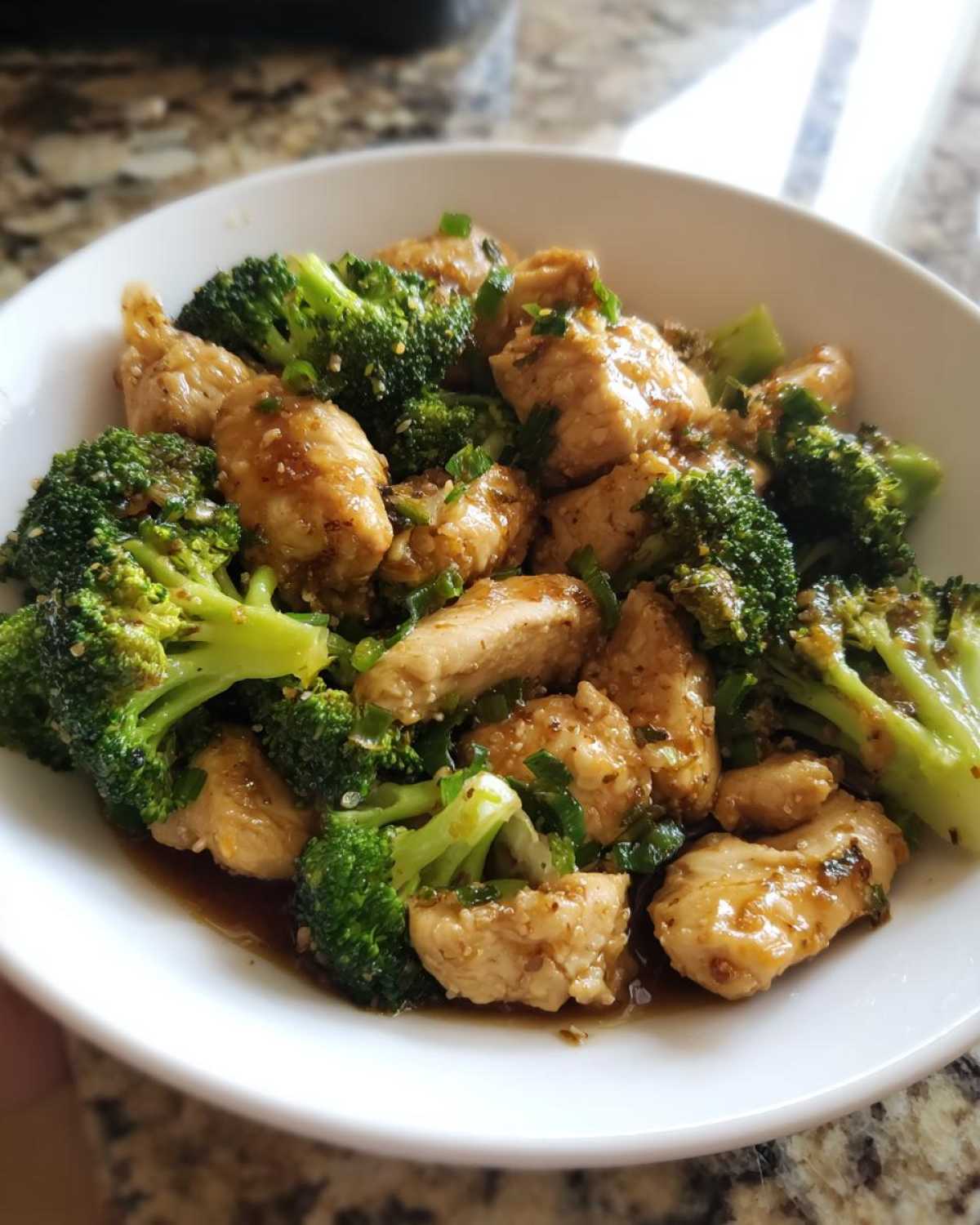 Close-up of tender chicken pieces and bright green broccoli florets coated in a savory sauce, served as Garlic Butter Chicken and Broccoli.