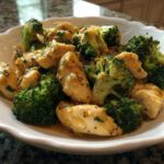 Close-up of tender chicken pieces and bright green broccoli florets coated in a glossy Garlic Butter Chicken and Broccoli sauce.