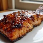 A close-up of a perfectly cooked fillet of Grilled Honey Mustard Salmon with a thick, shiny, caramelized glaze.