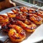 Close-up of perfectly grilled Honey Garlic Grilled Shrimp skewers with a caramelized, glossy glaze.