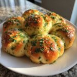 A cluster of freshly baked, golden brown Garlic Knots glistening with butter and topped with chopped parsley.