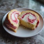 Two cross-sections of fluffy Strawberry Cheesecake Sweet Rolls showing the swirl of cream cheese and strawberry filling.